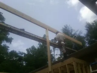 Carpenter setting a ridge beam over a new addition frame — Ice Dam Removal by Roofing Brothers in Pablo