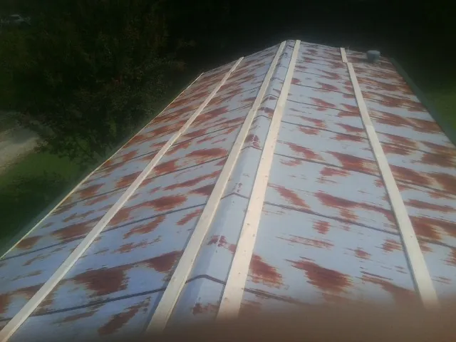 Rusted metal roof panels with new wood purlins before replacement — Storm Damage Roof Repair in Pablo by Roofing Brothers