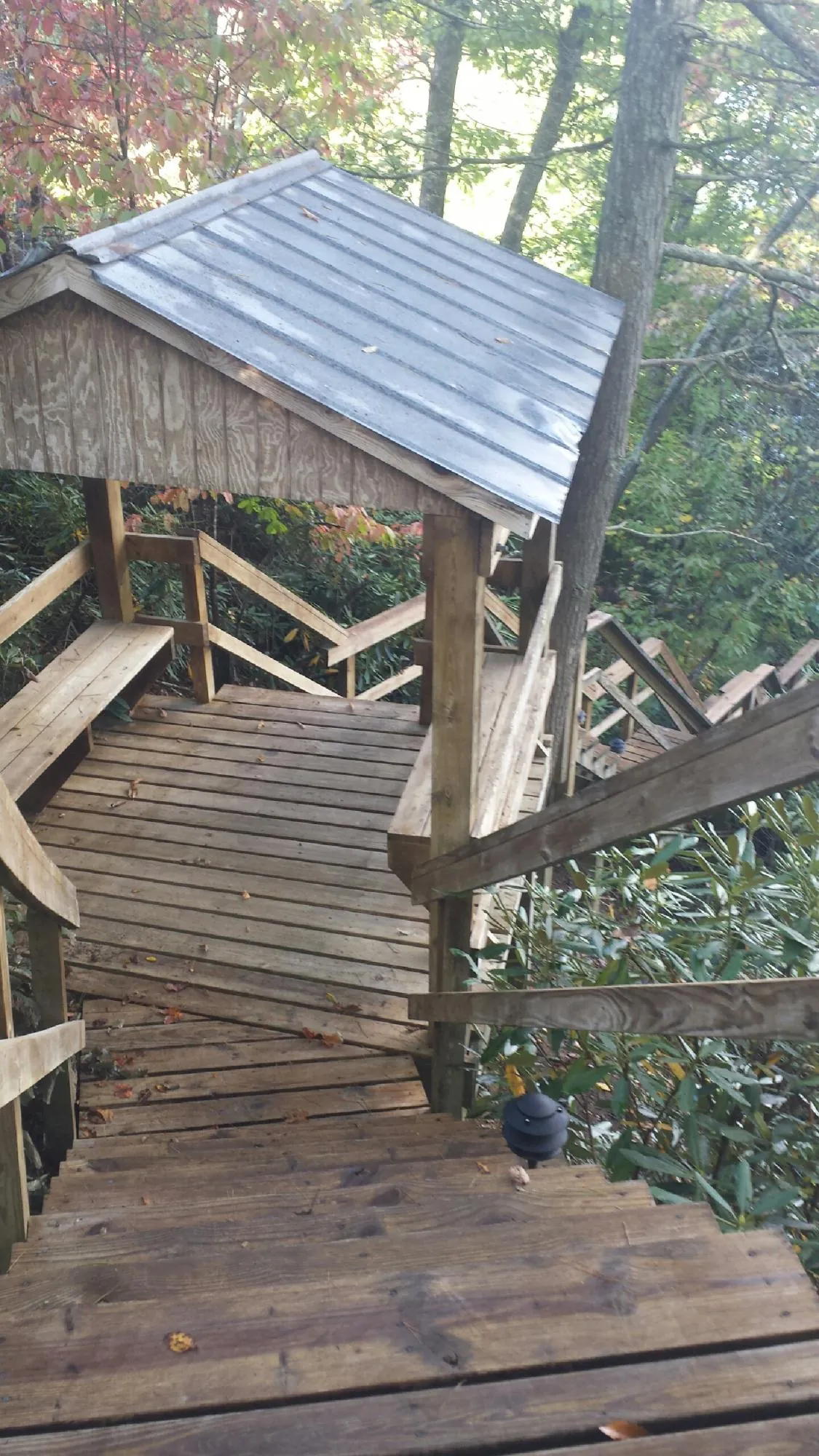 Metal roofed shelter over wooden steps on a wooded walkway — Skylight Repair & Installation work by our crew in Pablo
